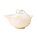 Front view of an ivory-white teapot with a left-facing spout and sculpted loop lid handle on white