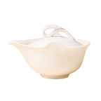 Front view of an ivory-white teapot with a left-facing spout and sculpted loop lid handle on white