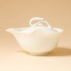 Three-quarter studio view of the ivory-white teapot on a warm beige background