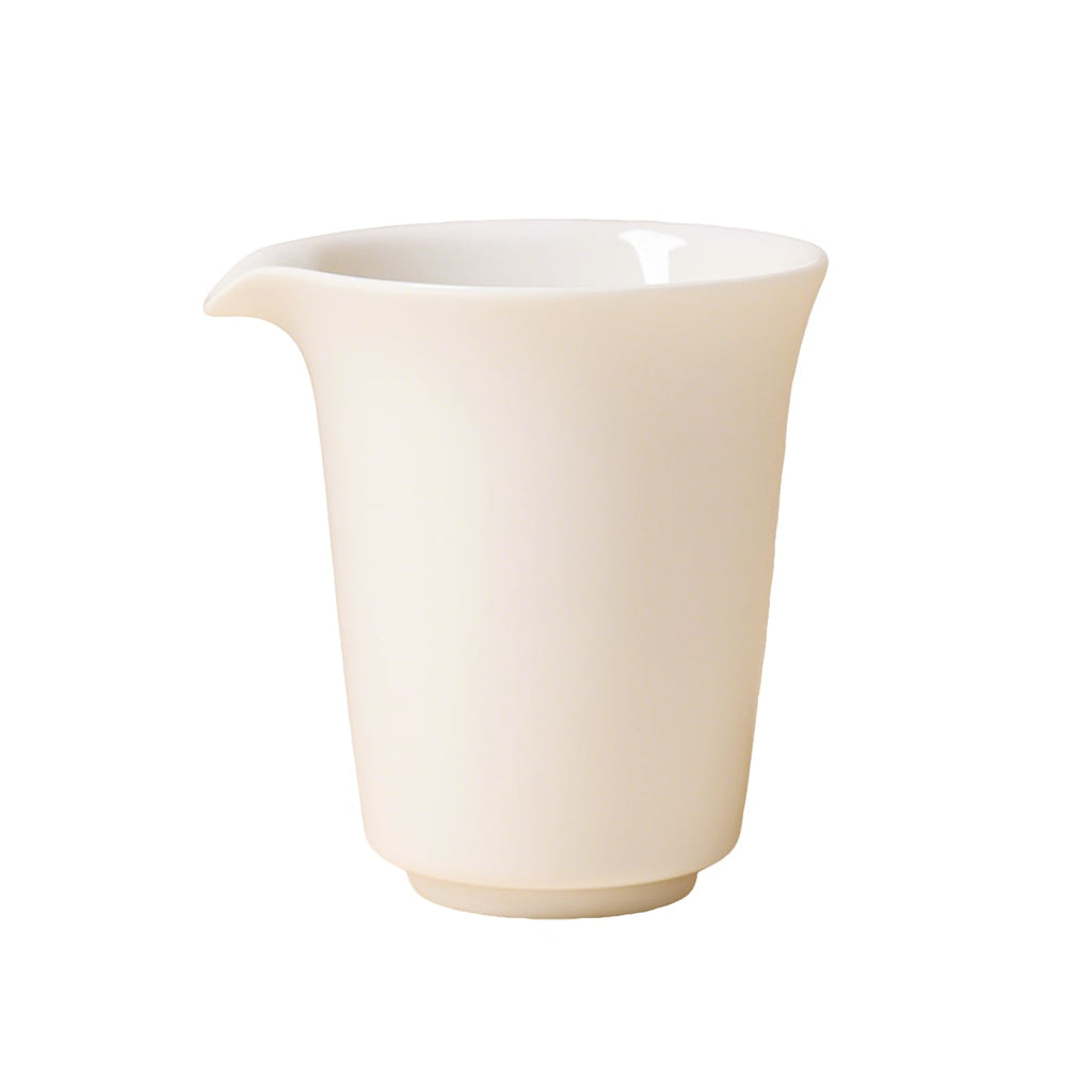 Front view of an ivory-white handleless pitcher with a flared rim and left-facing pouring lip on white