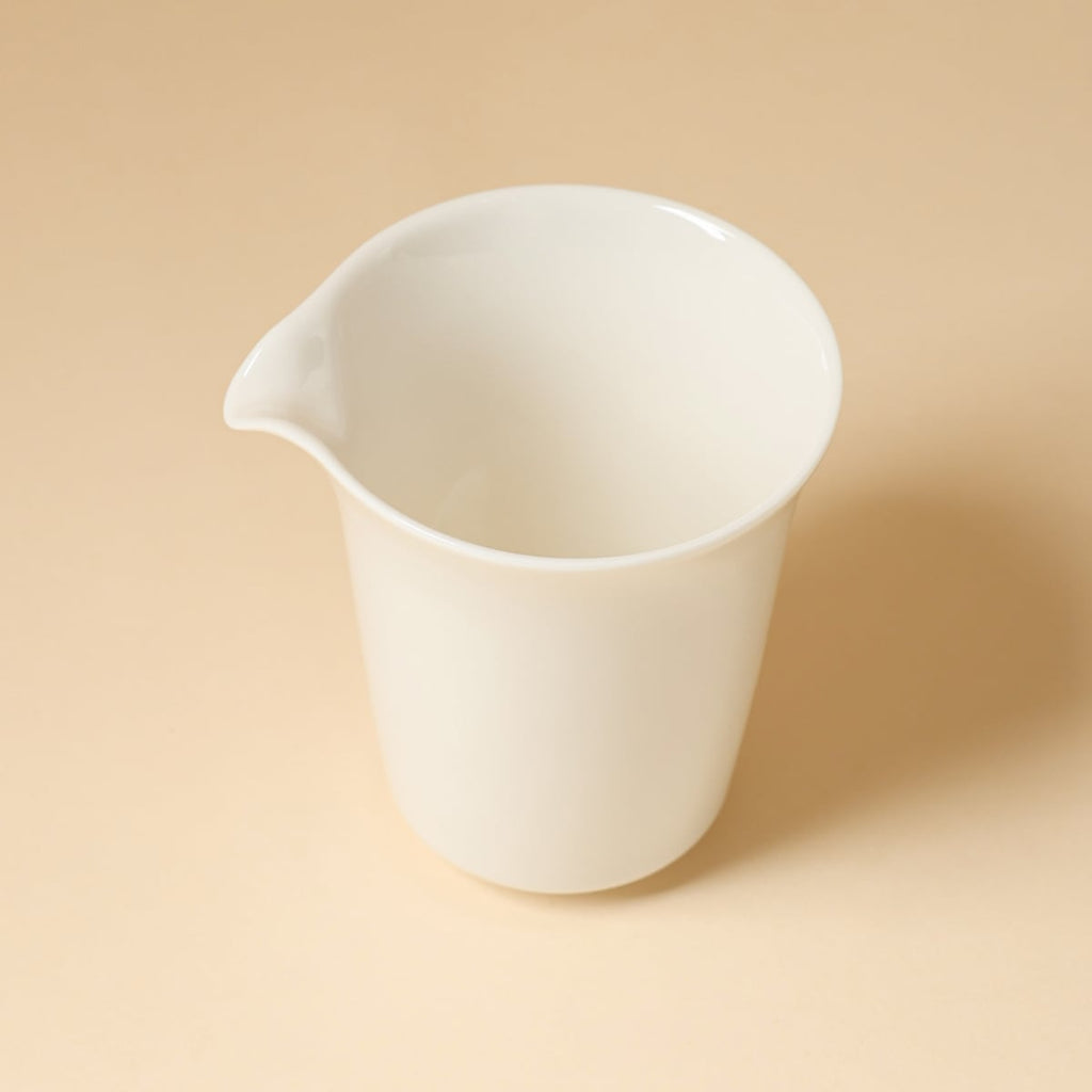 High-angle view into the ivory-white pitcher showing its open interior and pouring lip