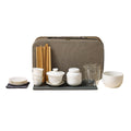 Portable white porcelain tea set with gaiwan, three cups and saucers, caddy, clear pitcher, tea tools and zip case