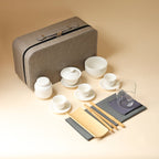 Portable tea set arranged with three cups and saucers, gaiwan, caddy, clear pitcher, tea tools and zip case