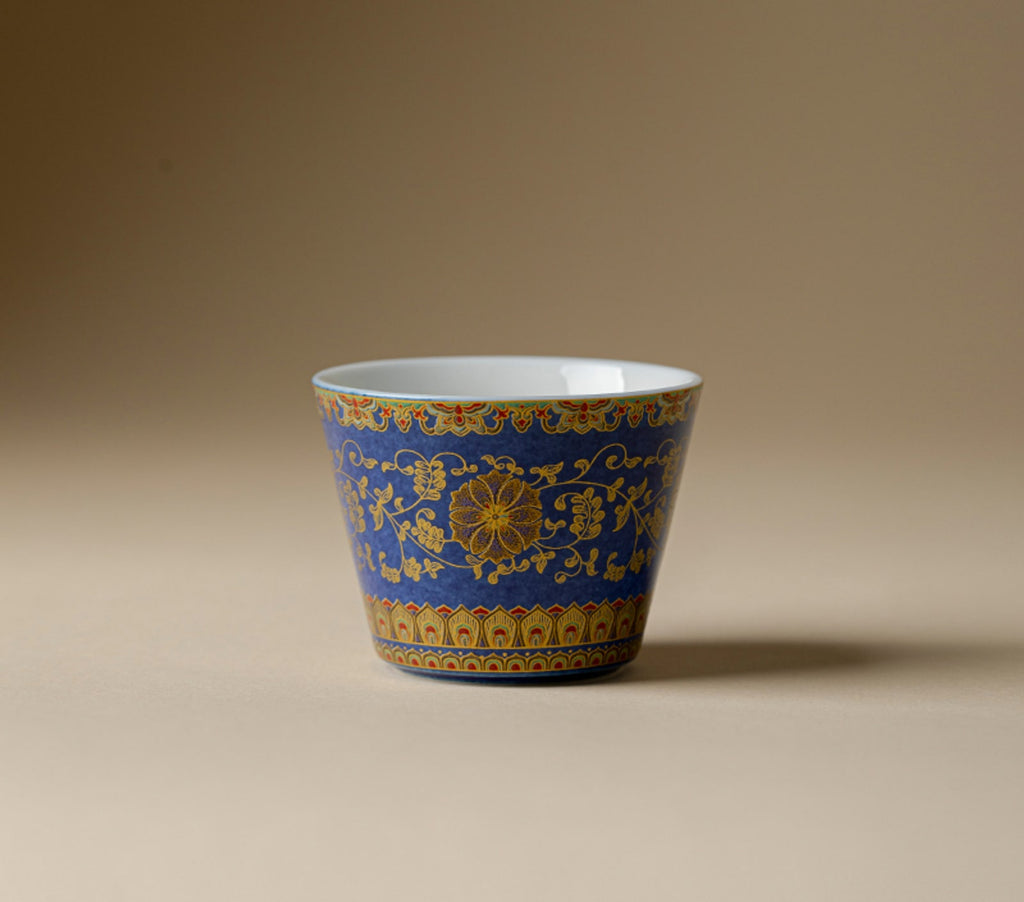 Front view of Qingding Gold Floral Tasting Cup with cobalt-blue exterior and pale interior