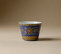Front view of Qingding Gold Floral Tasting Cup with cobalt-blue exterior and pale interior